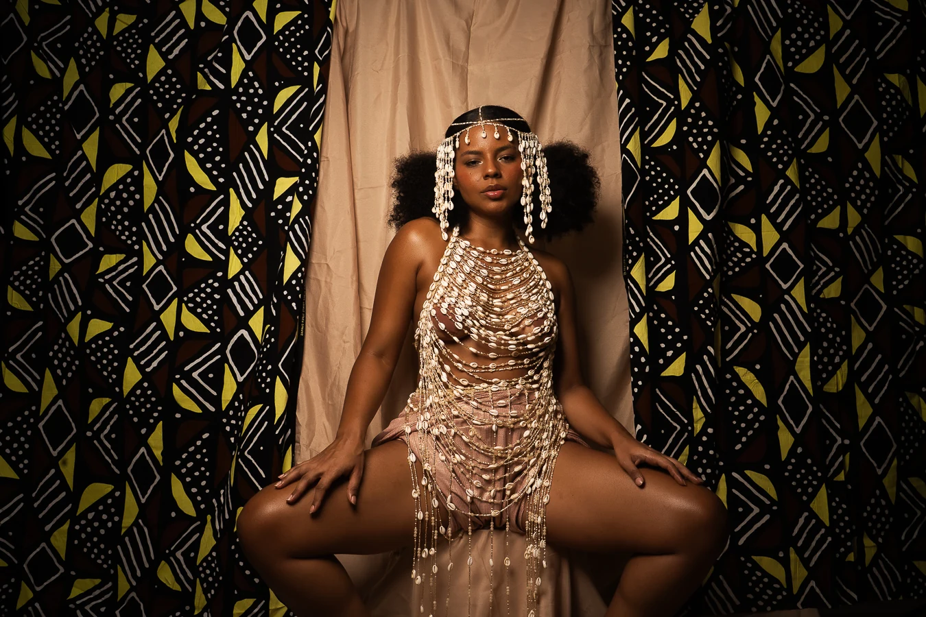 Micheleé seated wearing the eleé cowrie shell and chain design